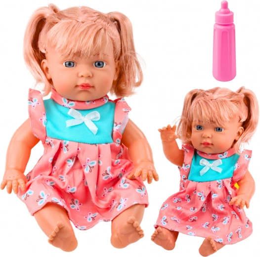 Bábu csecsemő színes ruhában, cumisüveggel és hangokkal