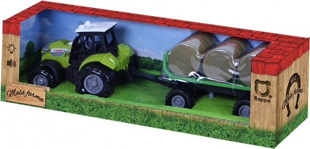 Traktor hanggal és fénnyel, pótkocsival és szalmakötegekkel