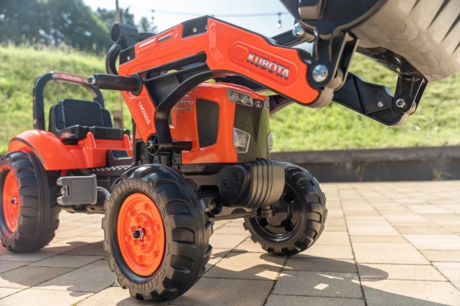 Traktor pedálos Kubota narancssárga utánfutóval és első markolóval