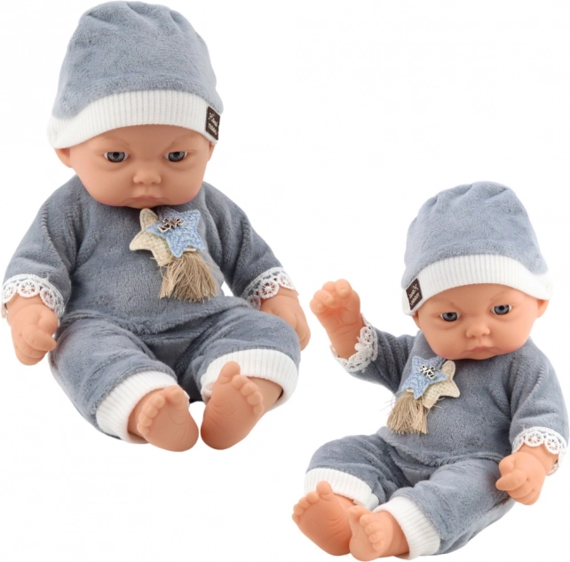 Bébi baba szürke pizsamában és sapkában