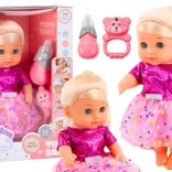 Baba rózsaszín ruhácskában, cumisüveggel és csörgővel, hangokkal és pisilő funkcióval